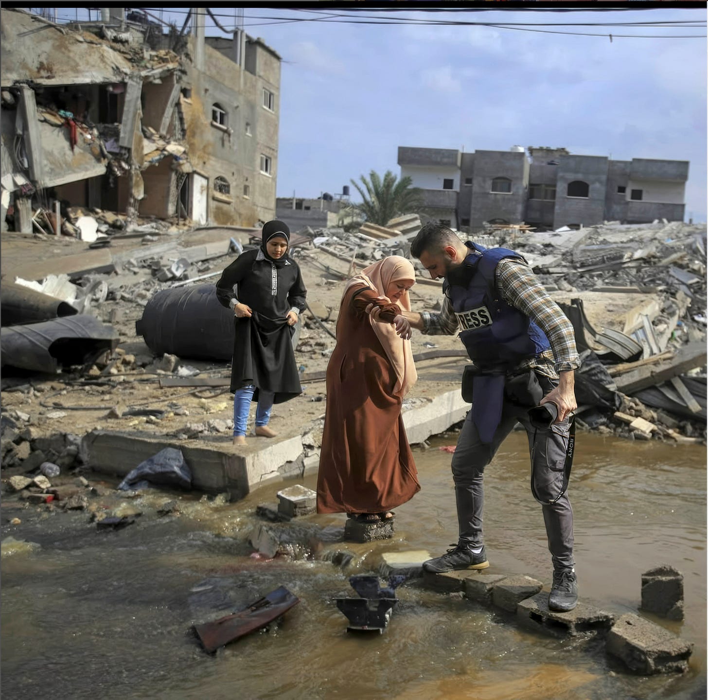In that day I gave her my hand to help her crossing the destroyed street but didn’t expect to hear from one this woman neighbors that she got killed months after this picture with all of her family. Just yesterday people were able to extract 30 bodies from under the rubble and one of them is this lady’s body.  Her name is Iktmal Barawi  One of the bodies next to her body, his name is Motaz also..