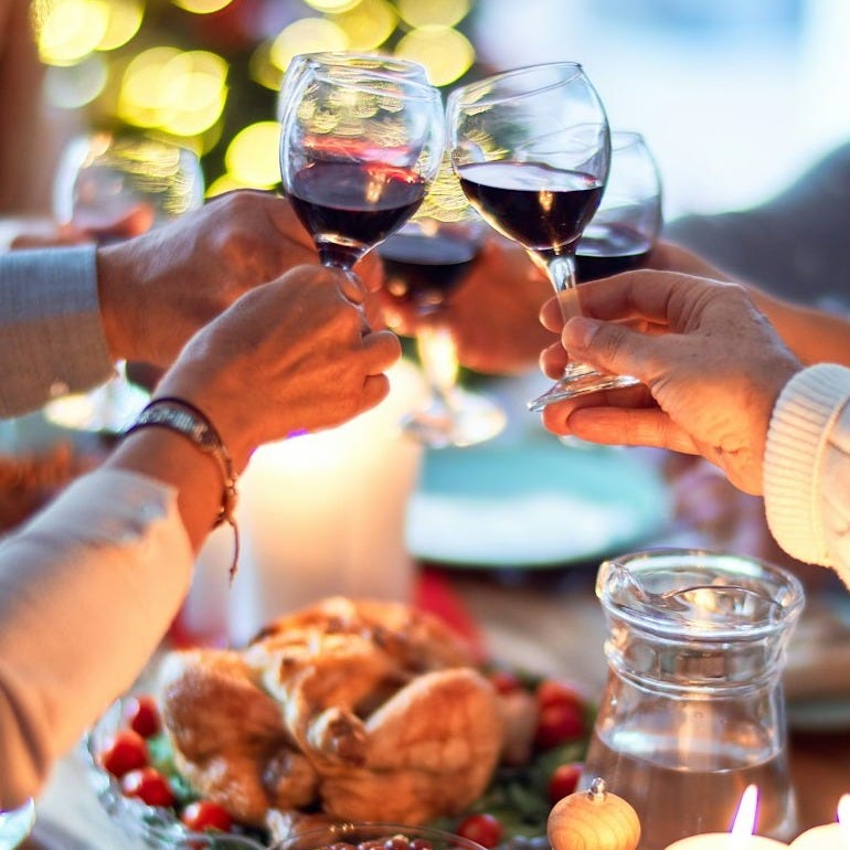 woman in white long sleeve shirt holding wine glass