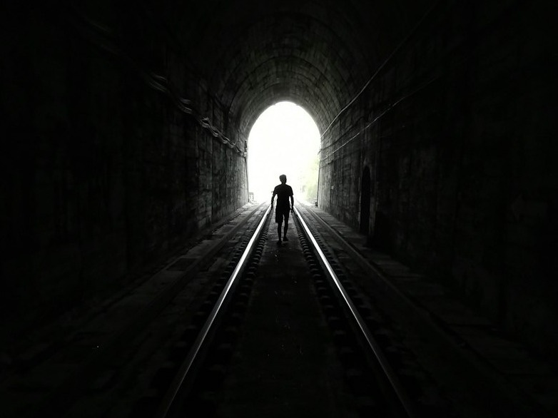 grayscale photo of tunnel with light grayscale photo of tunnel with light