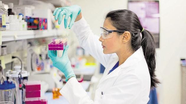 Closeup portrait, young scientist in labcoat doing experiments in lab, academic sector.