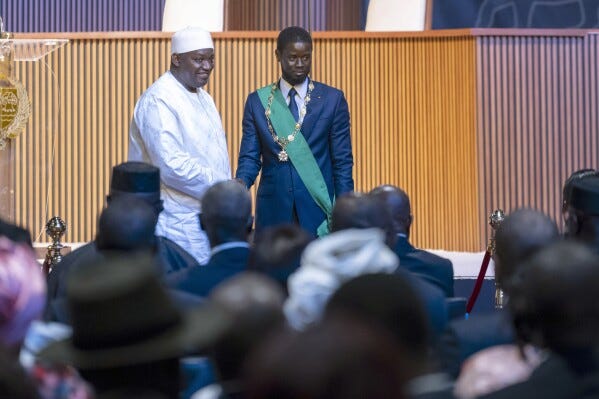 Bassirou Diomaye Faye, right, greets Gambia's President Adama Barrow during his swearing in ceremony as Senegal's president in Dakar, Senegal, Tuesday, April 2, 2024. Senegal has sworn in Bassirou Diomaye Faye as its new president, completing the previously little-known opposition figure’s dramatic ascent from prison to the palace in recent weeks. Faye was released from prison less than two weeks before the March election following a political amnesty announced by the outgoing president. (AP Photo/Sylvain Cherkaoui)