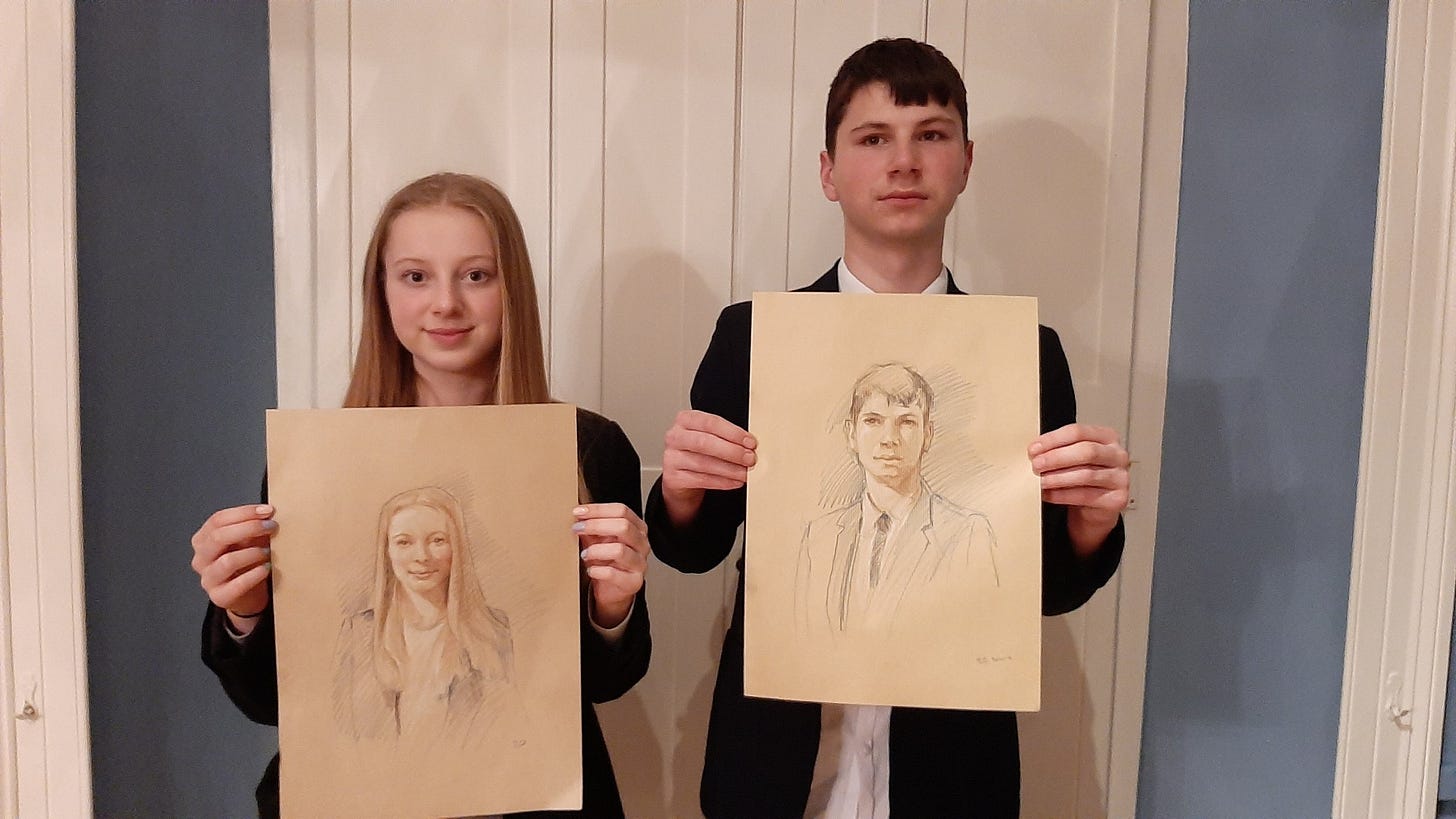 Photo of Izzi and Leon in school uniforms holding their portraits