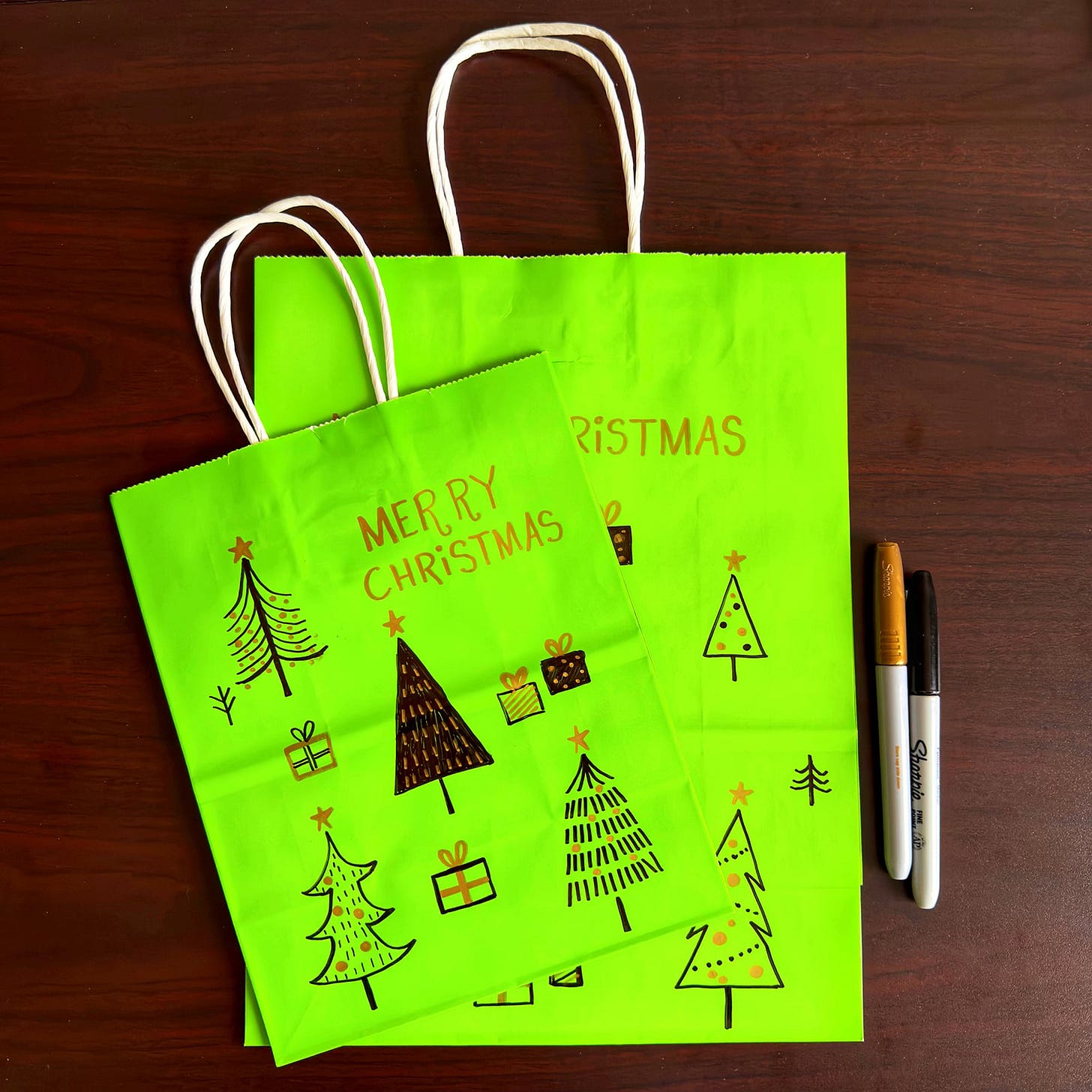 Gift bags with hand-drawn Christmas trees on them.