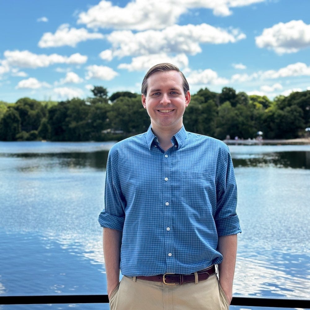 Bill Humphrey standing in front of Crystal Lake on a blue sky summer day