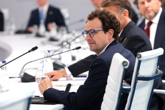 Dario Amodei, CEO of Anthropic, wearing a blue suit and glasses, at a working lunch during the G7 Summit