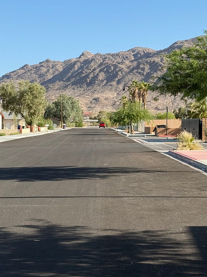 Street signs for Cholla Ave and 29 Palms Highway and completed work on road widening project on Cholla Ave.