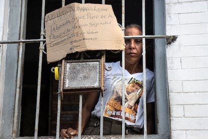 La madre de Duannis sostiene carteles que piden la libertad de su hijo en la ventana de su casa en Arroyo Naranjo, el 28 de julio de 2025, en Arroyo Naranjo, La Habana (Cuba).