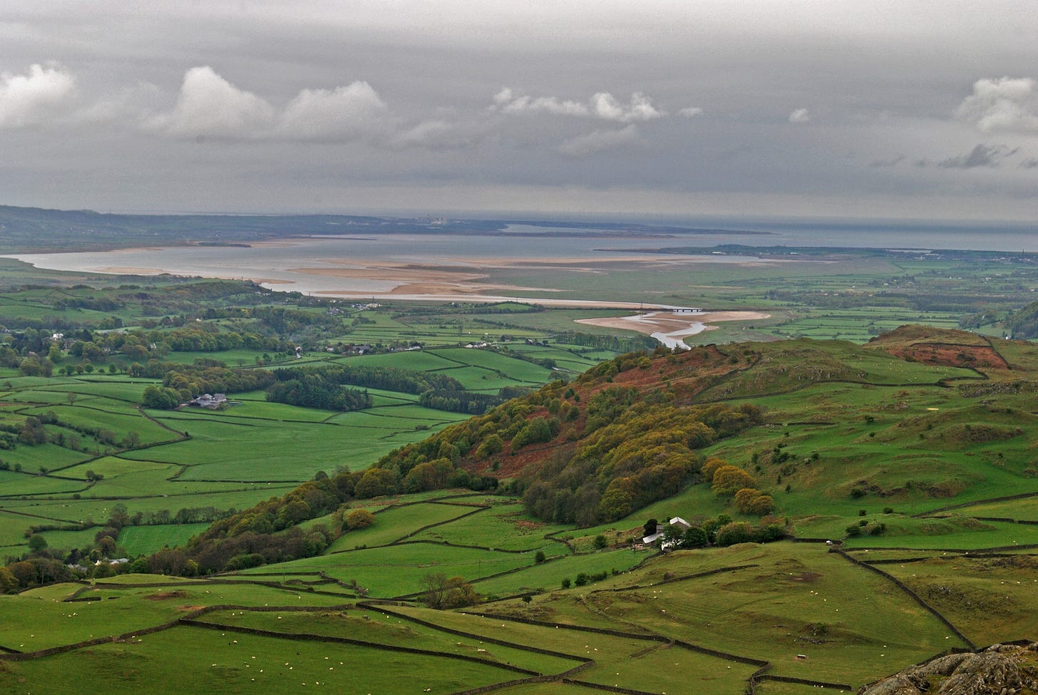 Green countryside, sandy estuary beyond