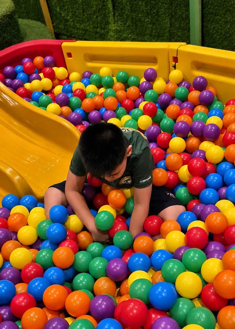 boy playing in a ball pit