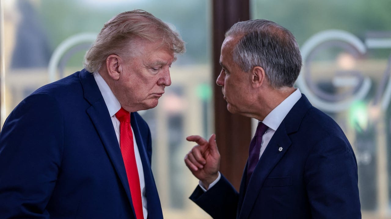 two men speaking at a meeting.