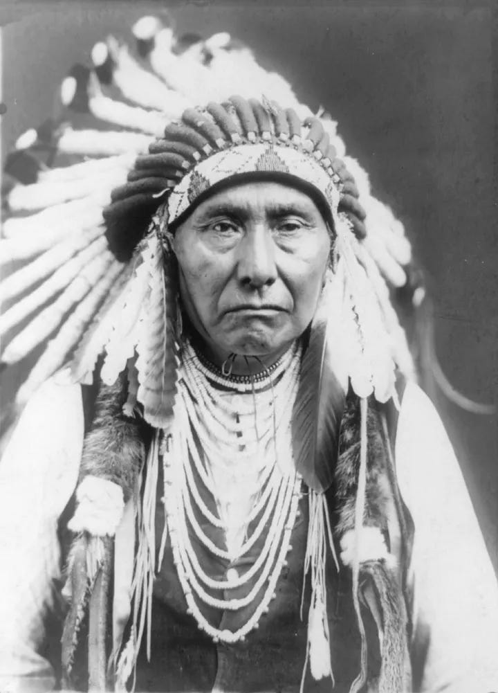 Historical photograph of Chief Joseph of the Nez Percé, wearing traditional dress with long braided hair, looking solemnly toward the camera. Historical photograph of Chief Joseph of the Nez Percé, wearing traditional dress with long braided hair, looking solemnly toward the camera.