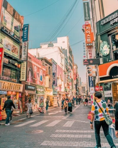 people walking on road surrounded by buildings people walking on road surrounded by buildings