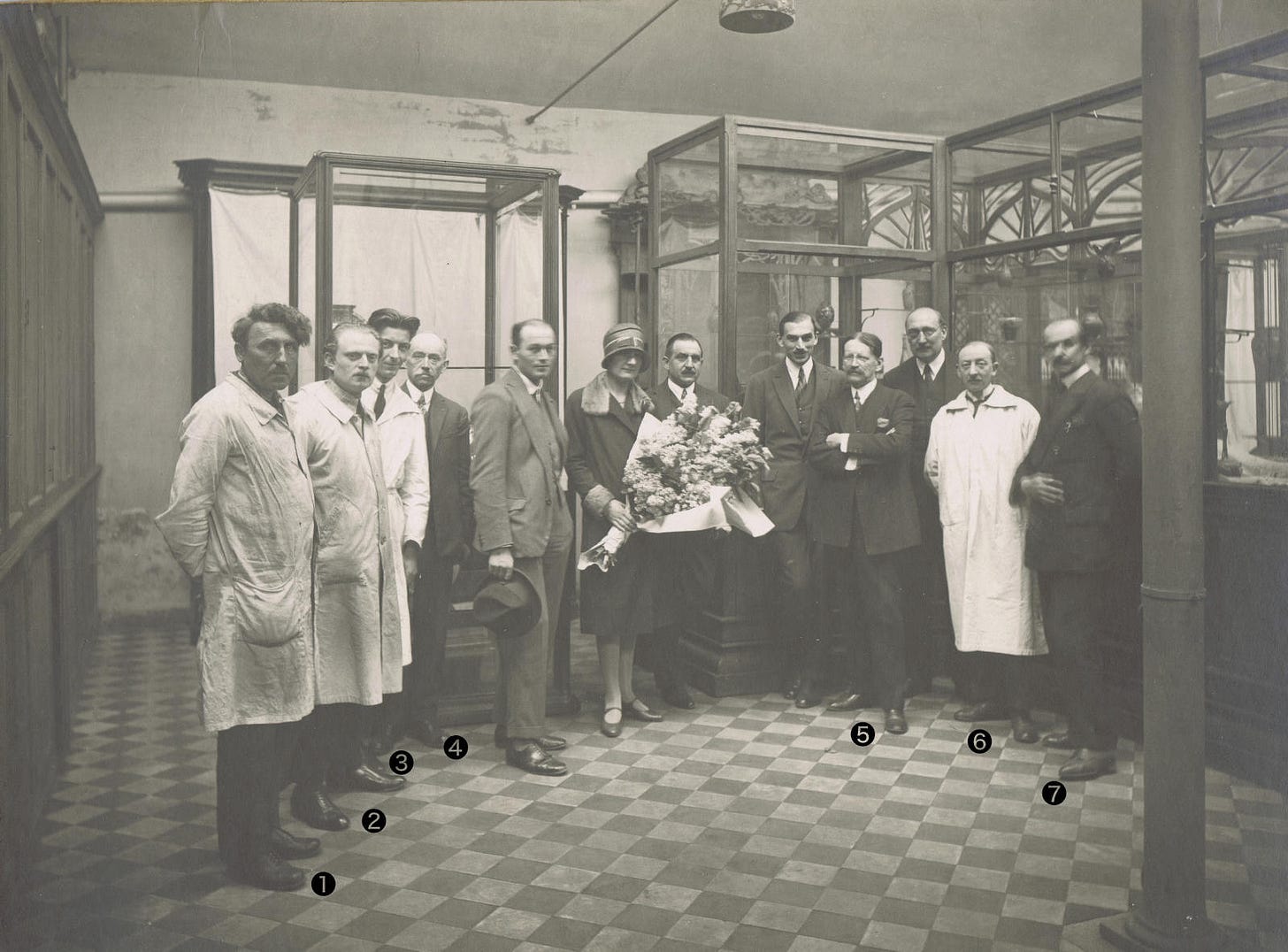 Alfred Machin (first left, #1) among the senior staff of the Gallé factory (#2. Georges Déthorey, designer ; #3. Théodore Ehrhart, designer ; #4. Émile Lang, director of the factory ; #5. Paul Perdrizet, general director ; #6. Louis Léonard, modeler ; #7. Auguste Herbst, chief designer), picture taken by Hippolyte Dubois during the visit of the aviator Marc Bernard, May 1927 (private collection). Alfred Machin (first left, #1) among the senior staff of the Gallé factory (#2. Georges Déthorey, designer ; #3. Théodore Ehrhart, designer ; #4. Émile Lang, director of the factory ; #5. Paul Perdrizet, general director ; #6. Louis Léonard, modeler ; #7. Auguste Herbst, chief designer), picture taken by Hippolyte Dubois during the visit of the aviator Marc Bernard, May 1927 (private collection).