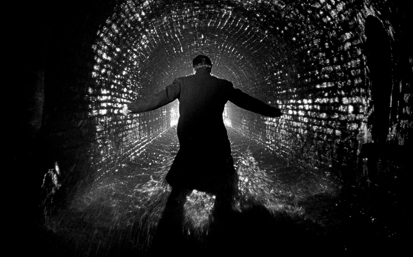 Harry Lime stands silhouetted in a wet, echoing sewer tunnel during the climactic chase of The Third Man, surrounded by glinting light and shadow. Harry Lime stands silhouetted in a wet, echoing sewer tunnel during the climactic chase of The Third Man, surrounded by glinting light and shadow.