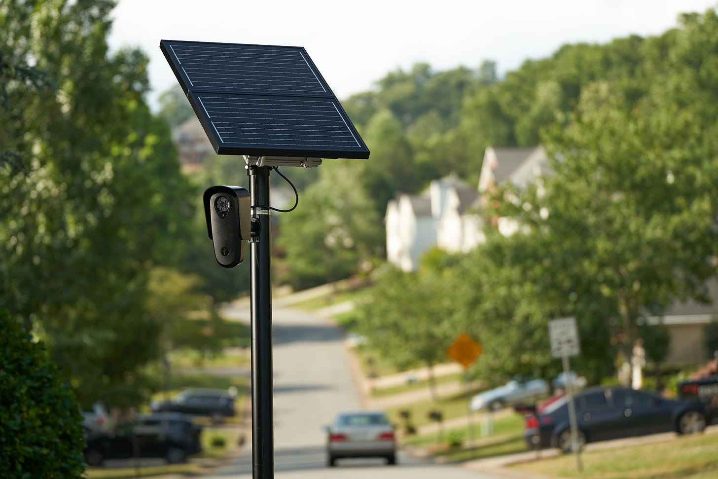 A photo of a Flock Safety camera on a pole in a suburban neighborhood. A photo of a Flock Safety camera on a pole in a suburban neighborhood.