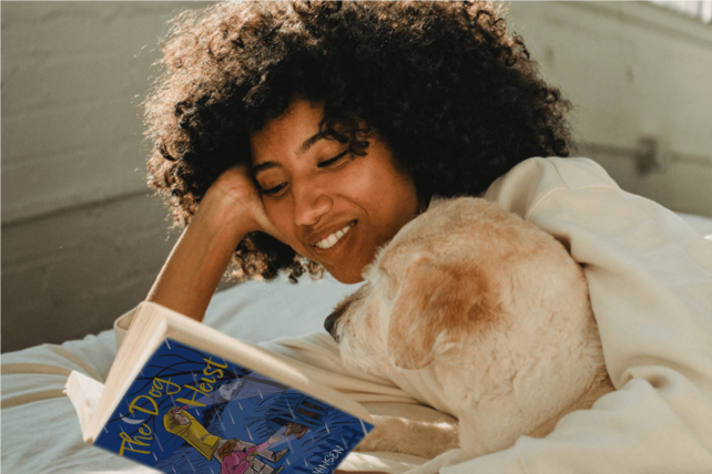 Girl with dog reading "The Dog Heist"