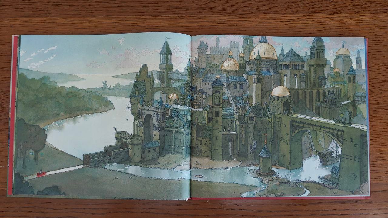Doppia pagina del libro "Viaggio" di Aaron Becker appoggiata su un tavolo di legno marrone. L'illustrazione occupa tutte e due le pagine e compare una bambina su una barca in un canale mentre approda verso una cittadina con un castello immerso nella natura.