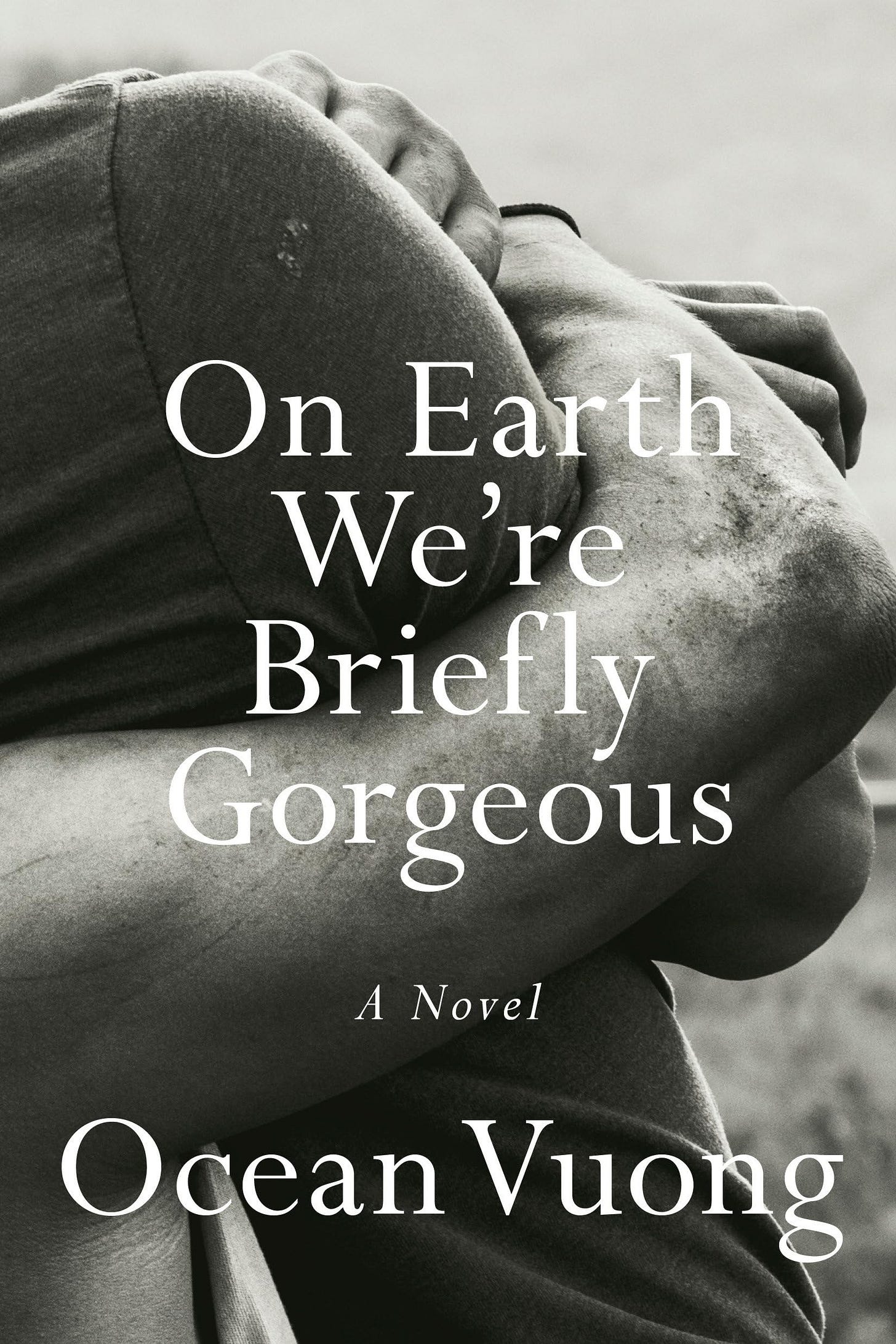 Cover of Ocean Vuong's On Earth We're Briefly Gorgeous. B&W photo of an embrace in the background, with the title and author in white text in front.