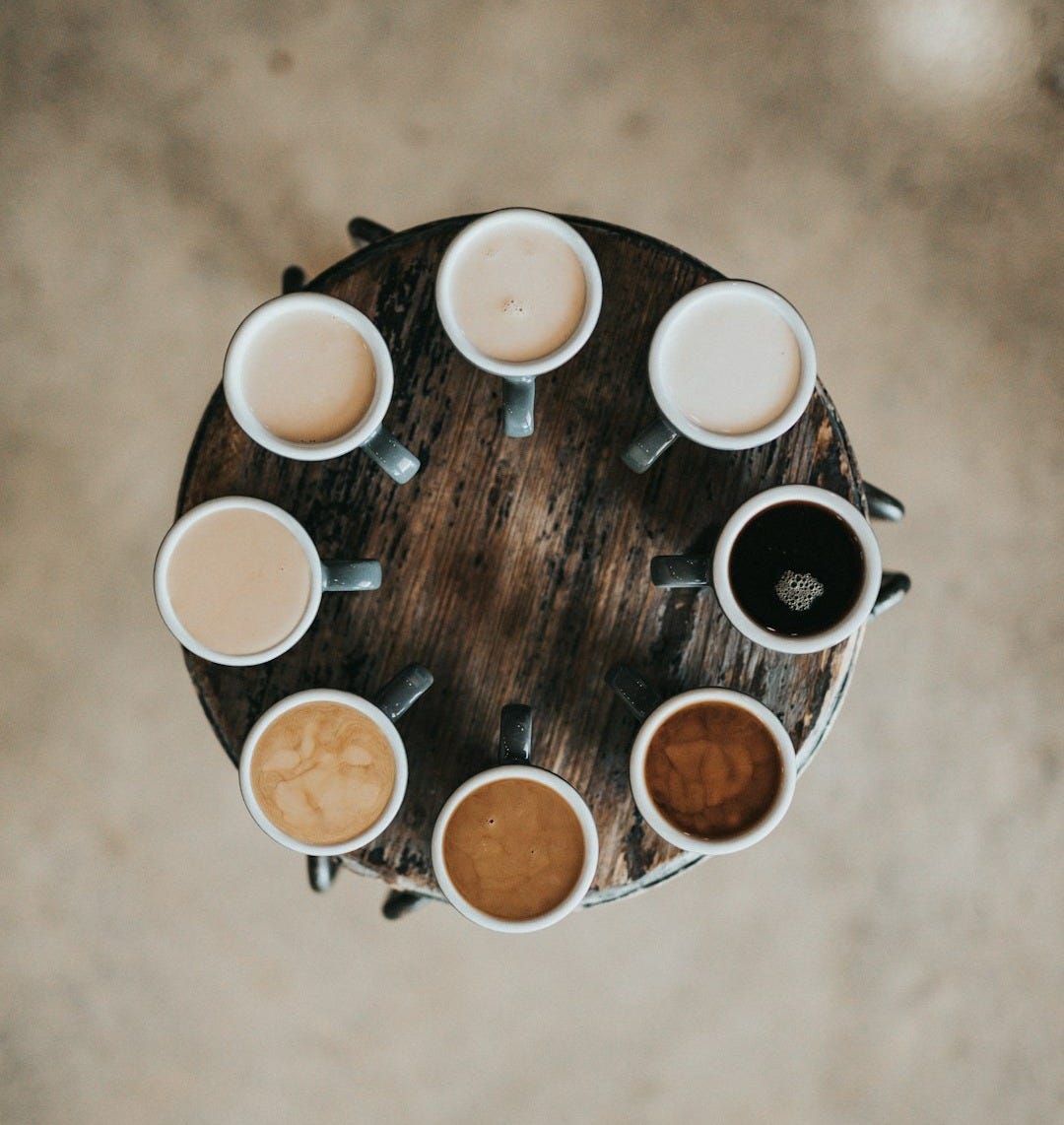 flat lay photography of eight coffee latte in mugs on round table flat lay photography of eight coffee latte in mugs on round table