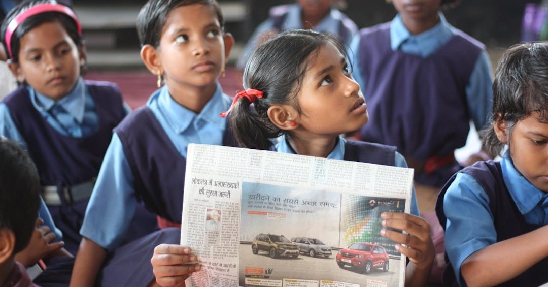 shallow focus photo of girl holding newspaper