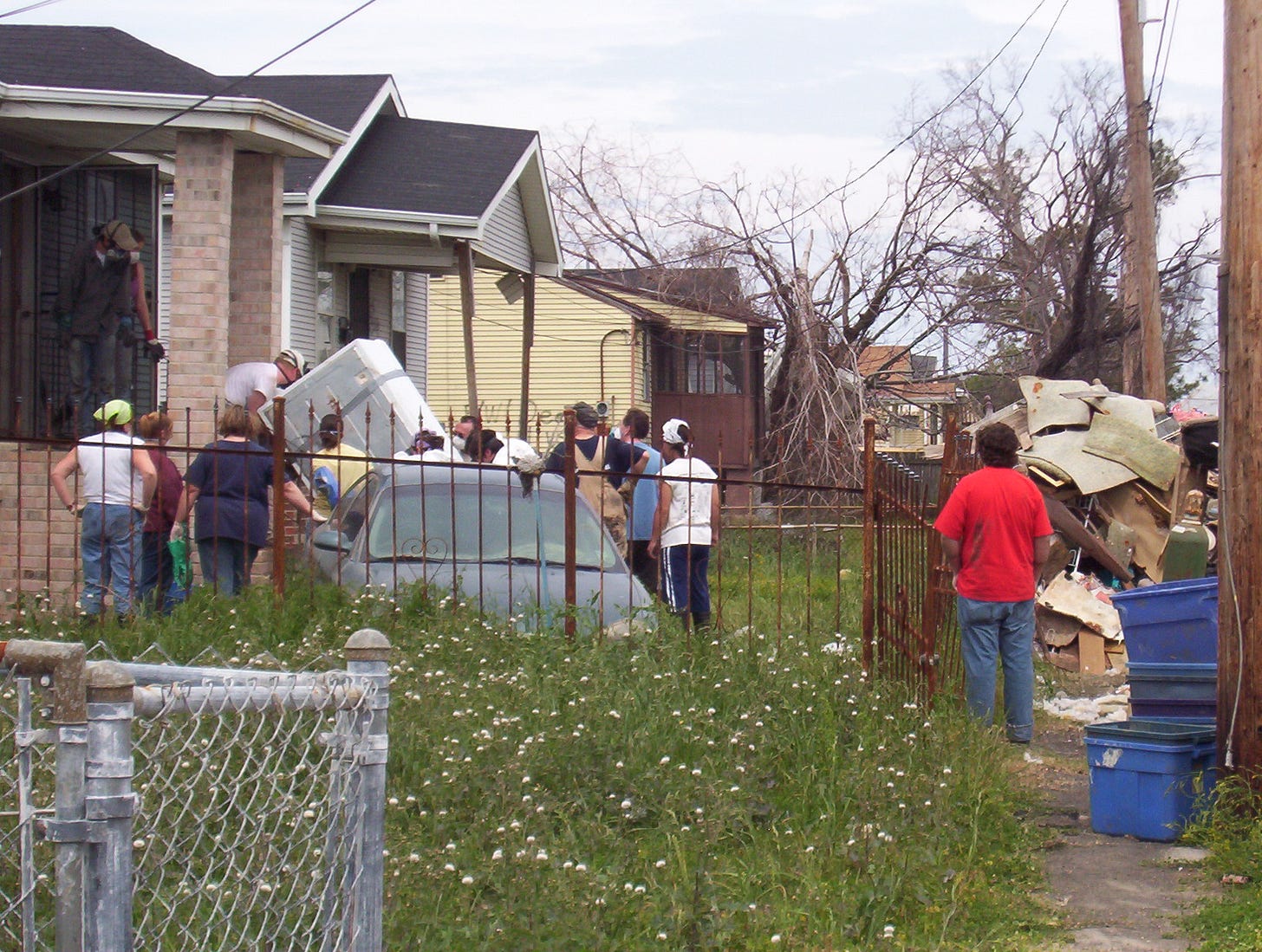 Volunteers pulling a refridgerator out of a house in the aftermath of Hurricane Katrina.