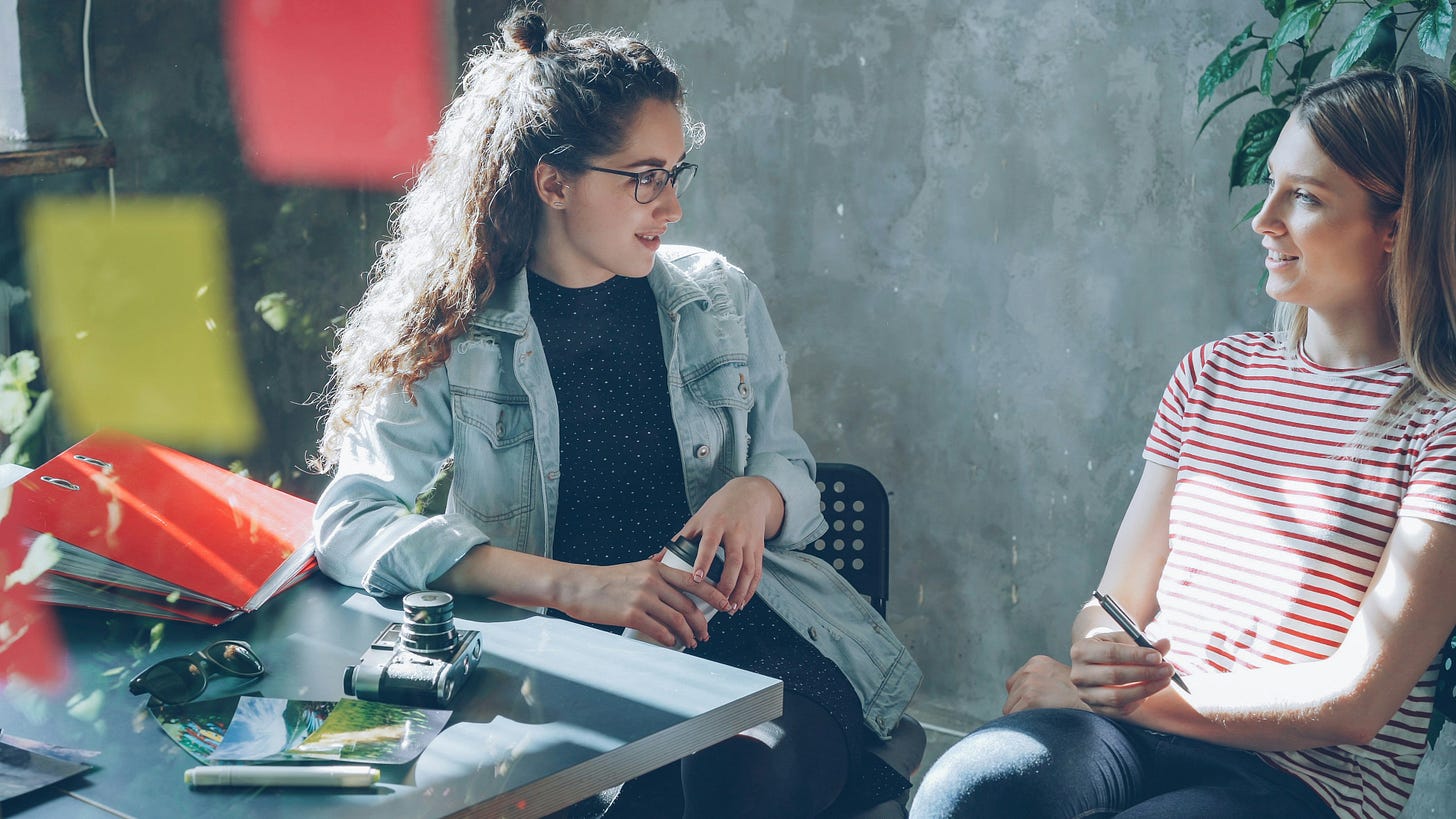 Two workmates in a pensive discussion Two workmates in a pensive discussion