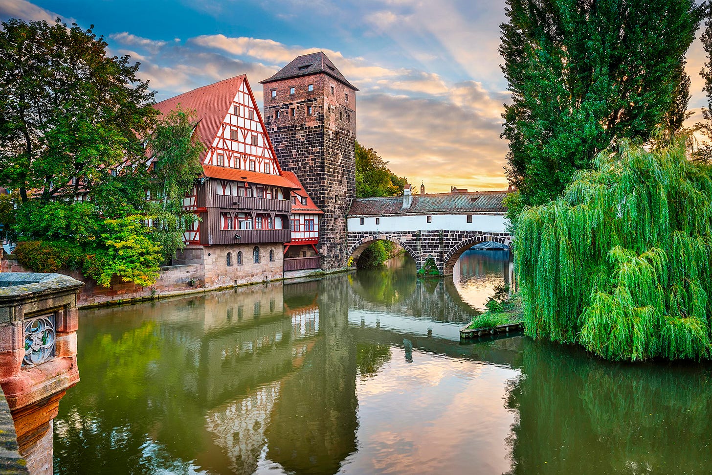 Scenic view of Nuremberg, Germany, with a river, bridge, and historic buildings.