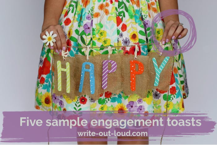 Girl wearing a flowery skirt, holding a piece of burlap, with the word HAPPY on it.