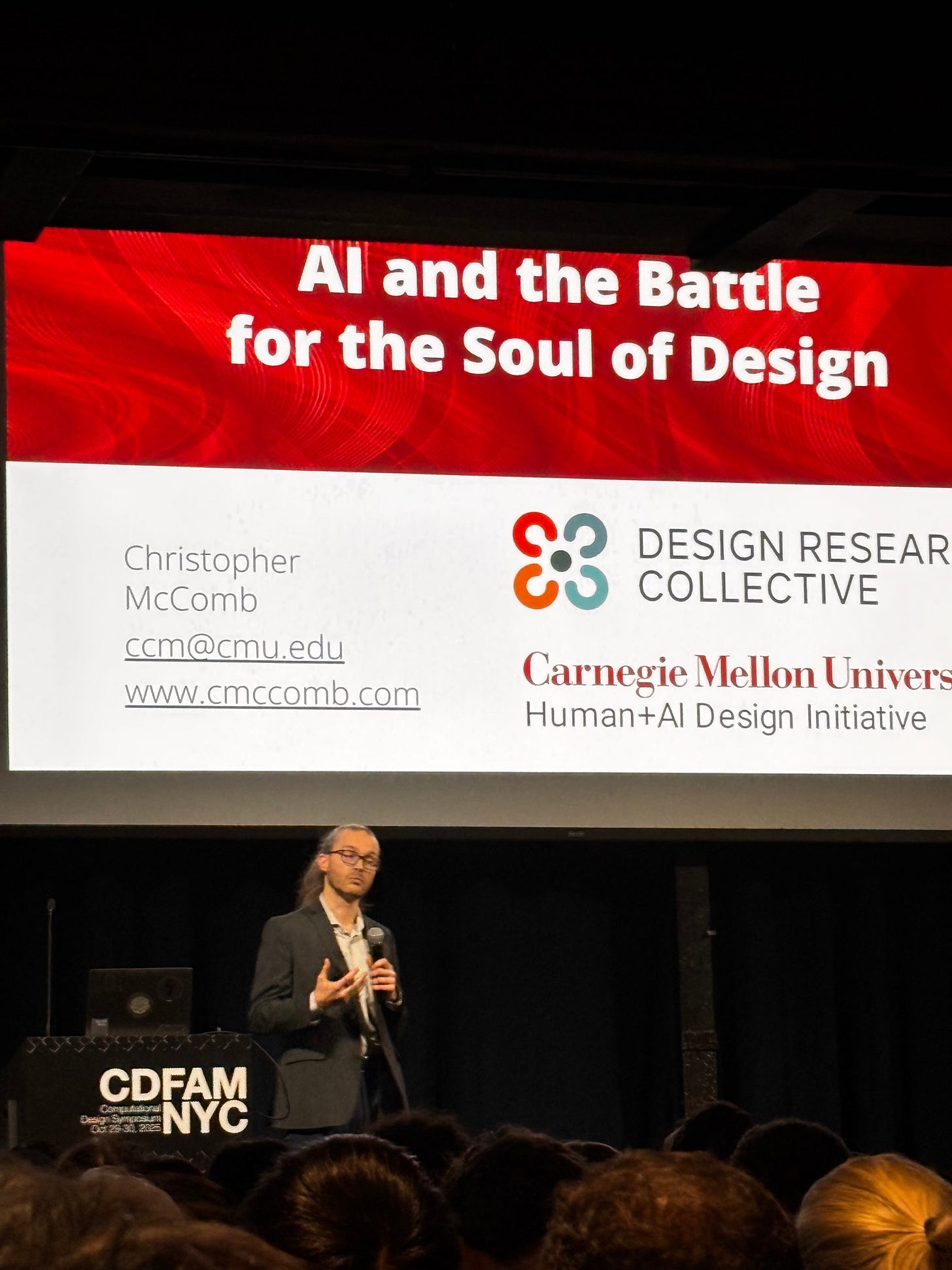 Chris McComb of CMUpresenting at a conference, with a slide titled 'AI and the Battle for the Soul of Design' behind him, representing the Design Research Collective from Carnegie Mellon University. The audience is visible in the foreground.