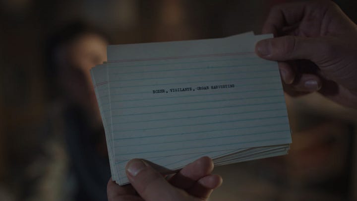 A notecard that says "Man, Woman, Cult, Rocket" and a notecard that says "Boxer, Vigilante, Organ Harvesting"