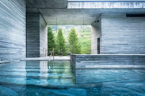 Interior of Therme Vals thermal baths by Peter Zumthor, Vals, Switzerland. Dark quartzite stone walls and thermal water pools lit by natural light from above. Architecture by Peter Zumthor.
