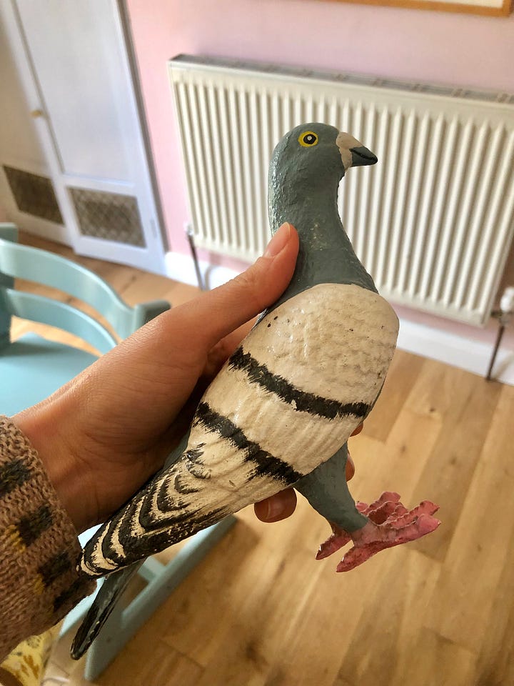 Photos showing a cast iron figure pigeon coming out of a cardboard box