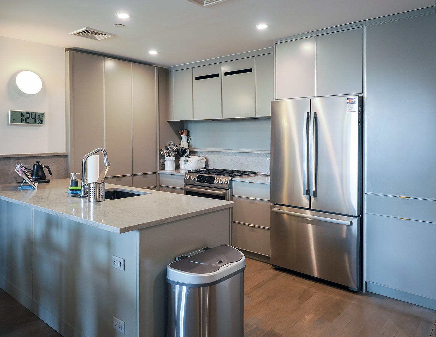 Kitchen with light coloured cupboards, and large built in fridge.