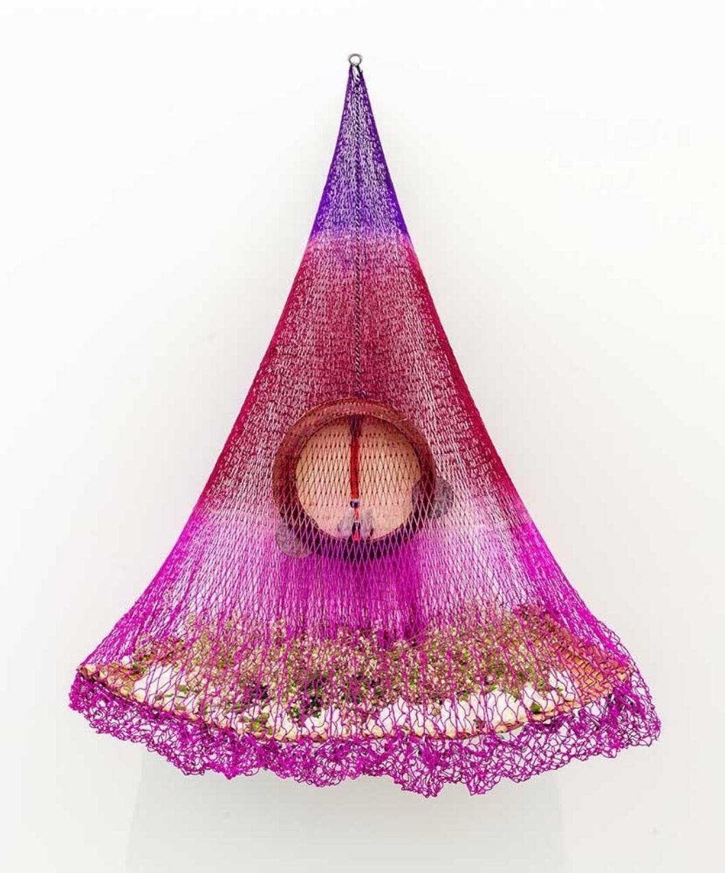 831 A conical red, pink, and maroon suspended sculpture made with fishing net titled, Nuestro Tiempo/Our Time, by Carolina Caycedo.