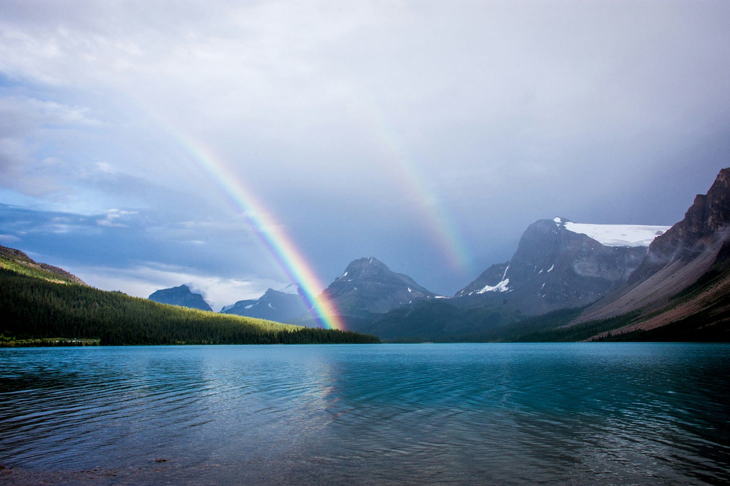 A beautiful double rainbow displaying over a clear blue lake and snow covered mountains. A beautiful double rainbow displaying over a clear blue lake and snow covered mountains.