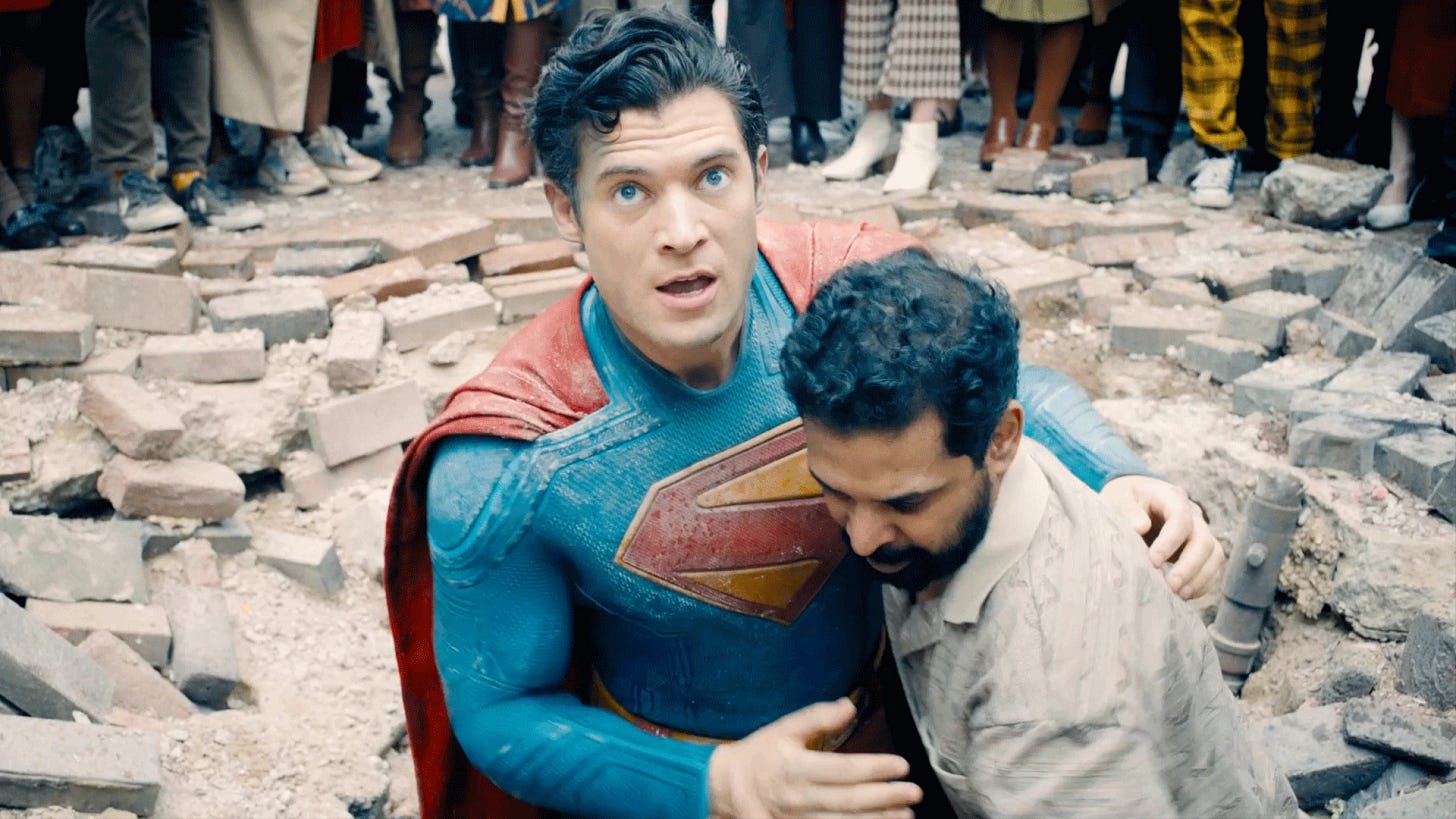 Superman (David Corensweat) e homem juntos, sob aparentes escombros no chão. 