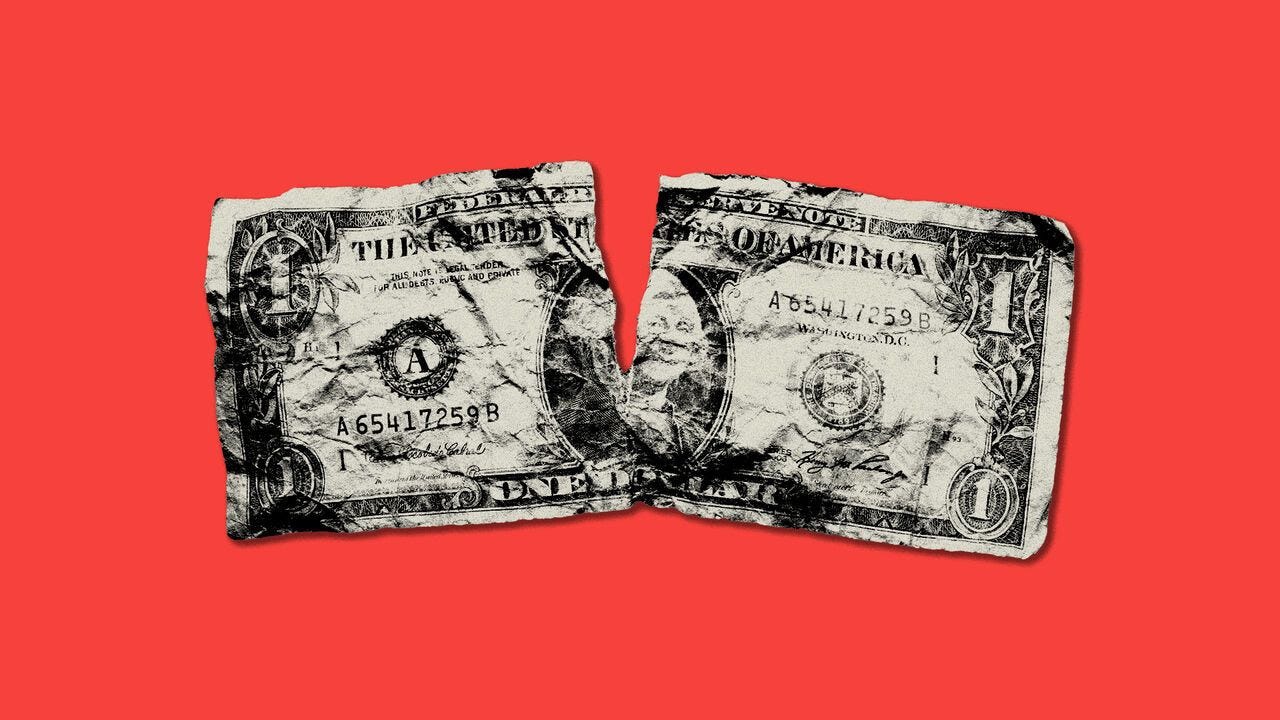 crumpled dollar bill with a rip in the middle on a red background