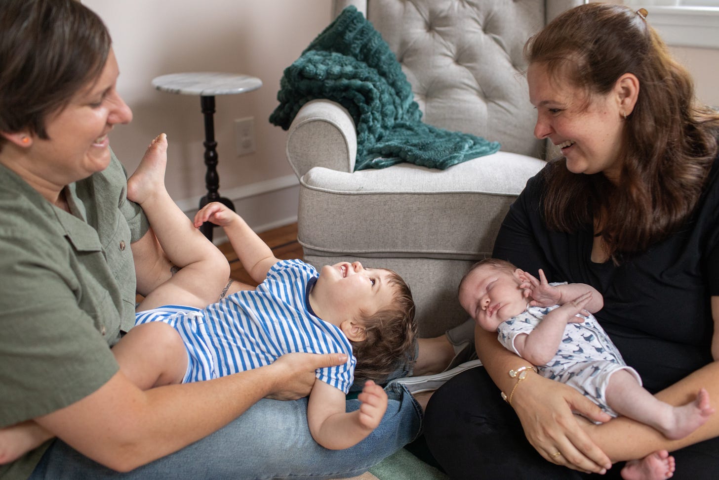 A family of four smiling with a new baby.