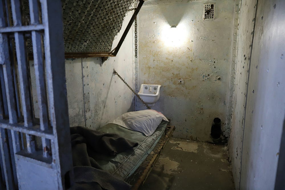 A tiny, grungy and cramped prison cell. A tiny, grungy and cramped prison cell.