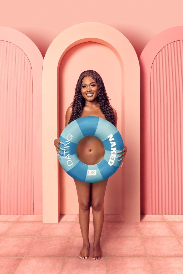 Woman holding a "Dating Naked UK" inflatable ring.