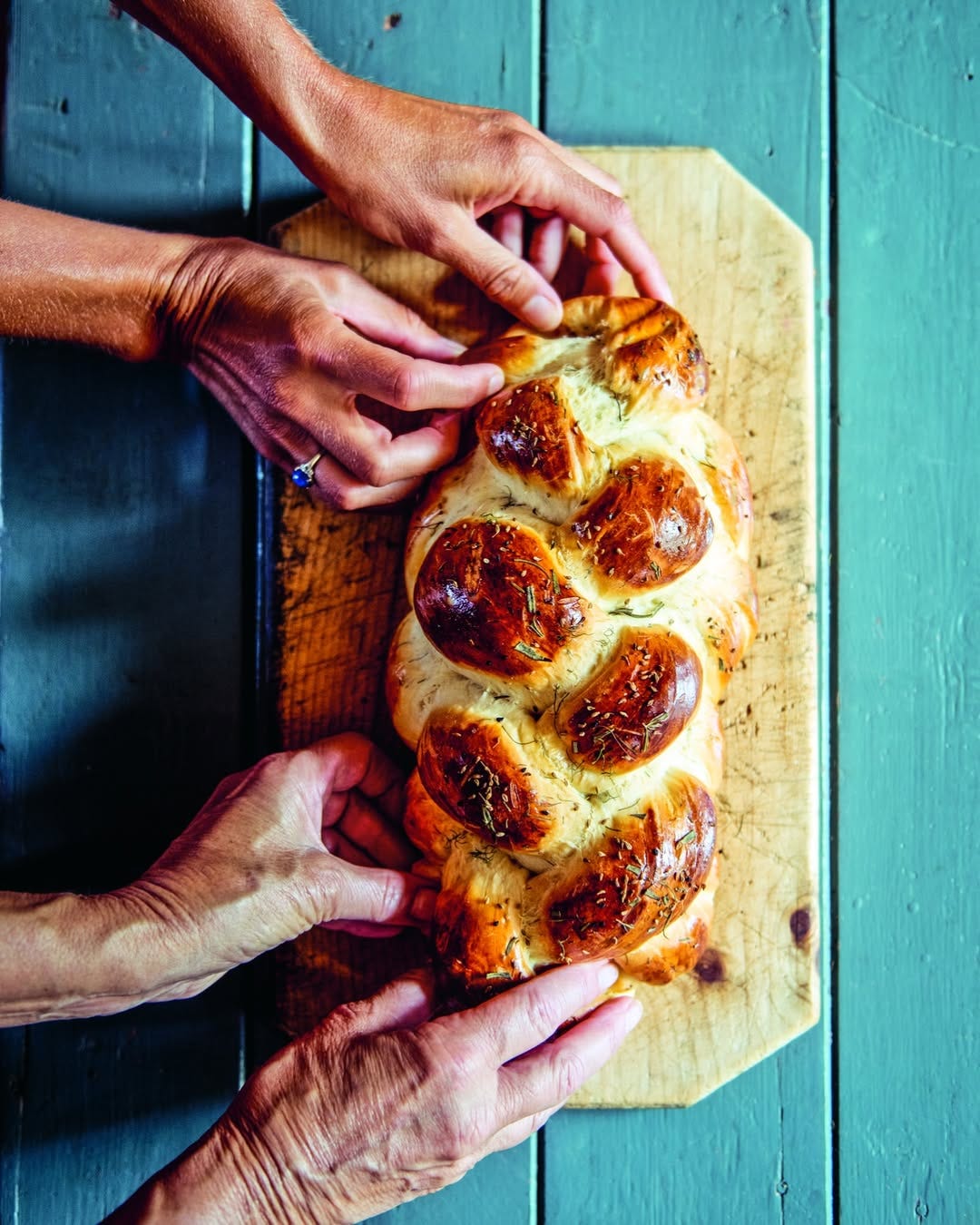 two sets of hands preparing a Challah bread two sets of hands preparing a Challah bread