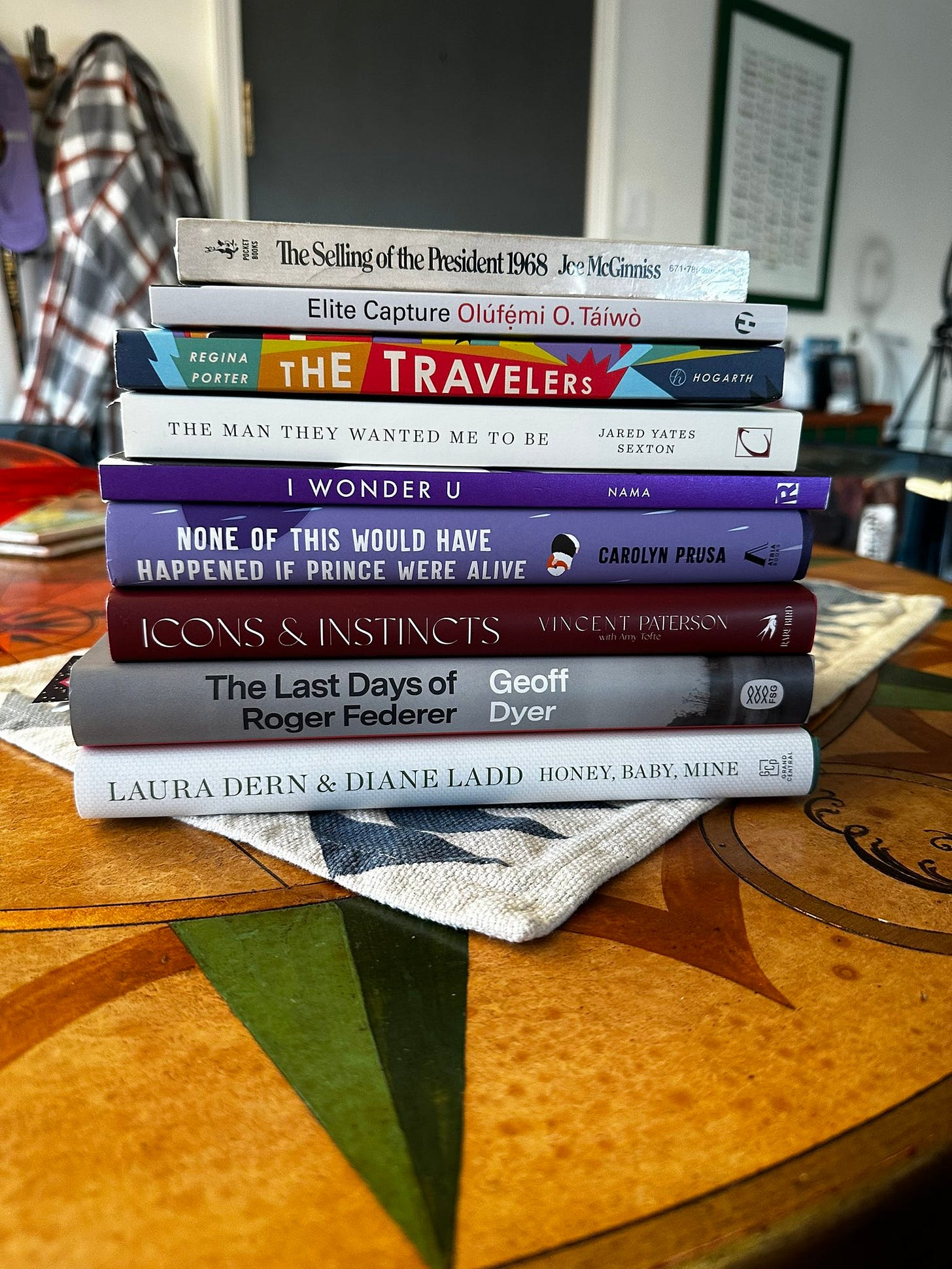 A stack of 9 books is show sitting on a table.