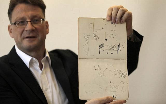 National Library archival expert and Humanities Collection Curator Stefan Litt shows drawings by novelist Franz Kafka, during a press conference in the National Library of Israel in Jerusalem, on August 7, 2019. Hundreds of letters, manuscripts, journals, notebooks, sketches and more - handwritten by Brod and Kafka - have been transferred to the National Library of Israel, following orders by Israeli and Swiss courts to open vaults in Zurich, which had stored the materials for decades. These materials, part of Max Brod's literary estate, have now been returned to Israel and have arrived at the National Library in Jerusalem, in accordance with Brod's wishes. (Menahem Kahana / AFP) National Library archival expert and Humanities Collection Curator Stefan Litt shows drawings by novelist Franz Kafka, during a press conference in the National Library of Israel in Jerusalem, on August 7, 2019. Hundreds of letters, manuscripts, journals, notebooks, sketches and more - handwritten by Brod and Kafka - have been transferred to the National Library of Israel, following orders by Israeli and Swiss courts to open vaults in Zurich, which had stored the materials for decades. These materials, part of Max Brod's literary estate, have now been returned to Israel and have arrived at the National Library in Jerusalem, in accordance with Brod's wishes. (Menahem Kahana / AFP)