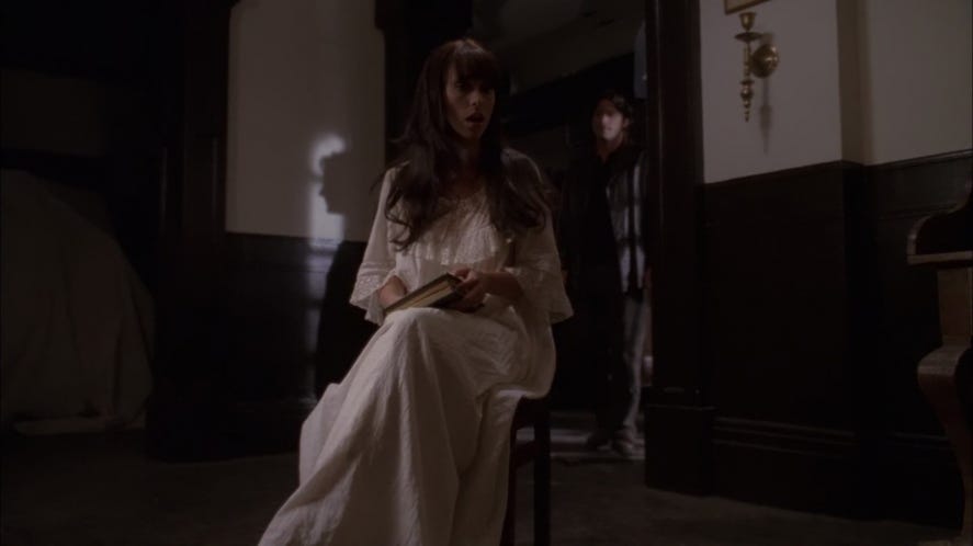 Jennifer Love Hewitt as Melinda Gordon reading a book to offscreen ghost children in the dark, while her husband watches from the doorway