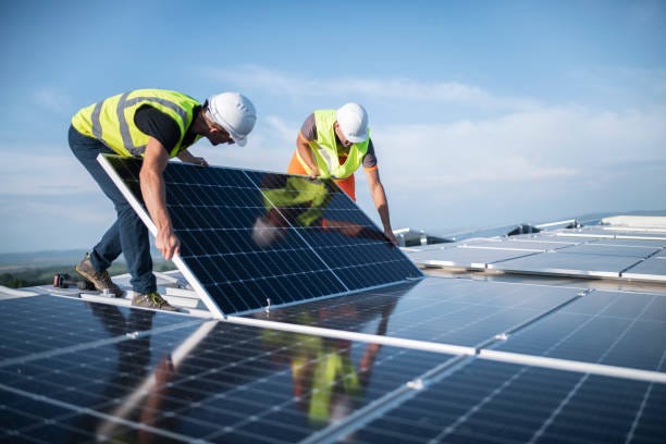 Two engineers installing solar panels on roof. Team of two engineers installing solar panels on roof. commercial solar panel stock pictures, royalty-free photos & images Two engineers installing solar panels on roof. Team of two engineers installing solar panels on roof. commercial solar panel stock pictures, royalty-free photos & images