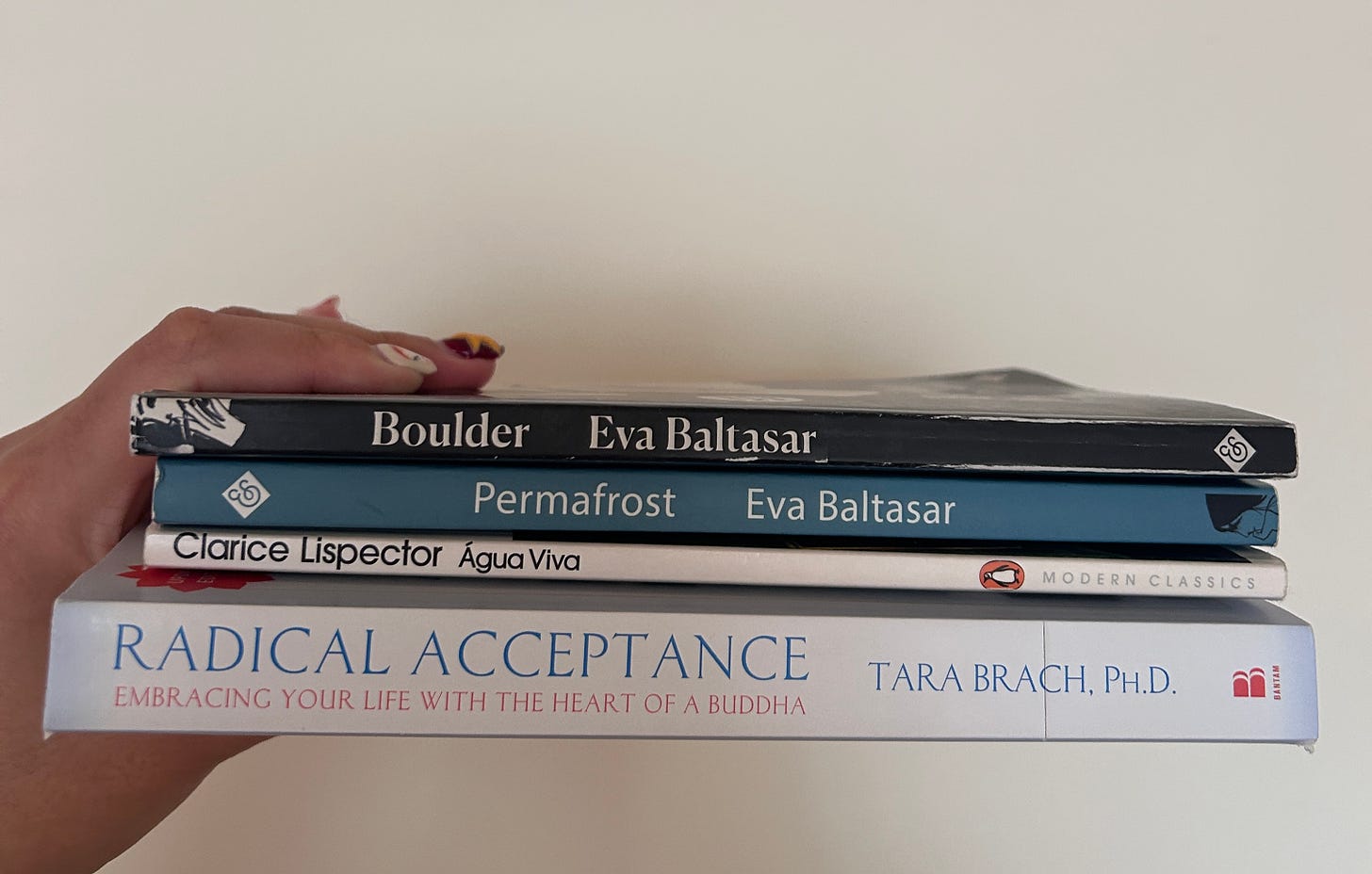 4 books: Boulder and Permafrost by Eva Baltasar, Agua Viva by Clarice Lispector, and Radical Acceptance by Tara Branch