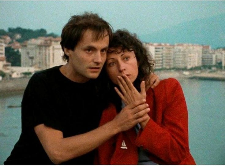 This may contain: two people standing next to each other near the water