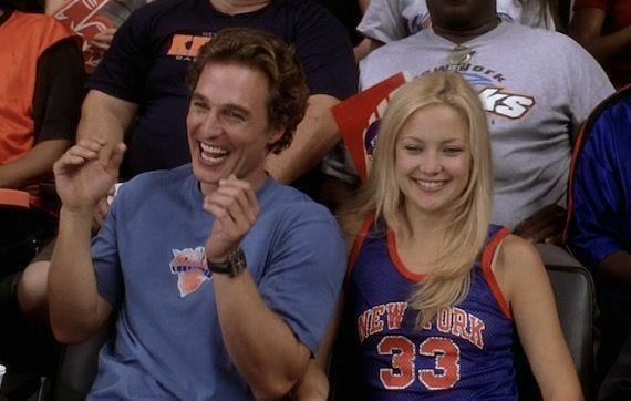 This may contain: two people sitting next to each other at a basketball game