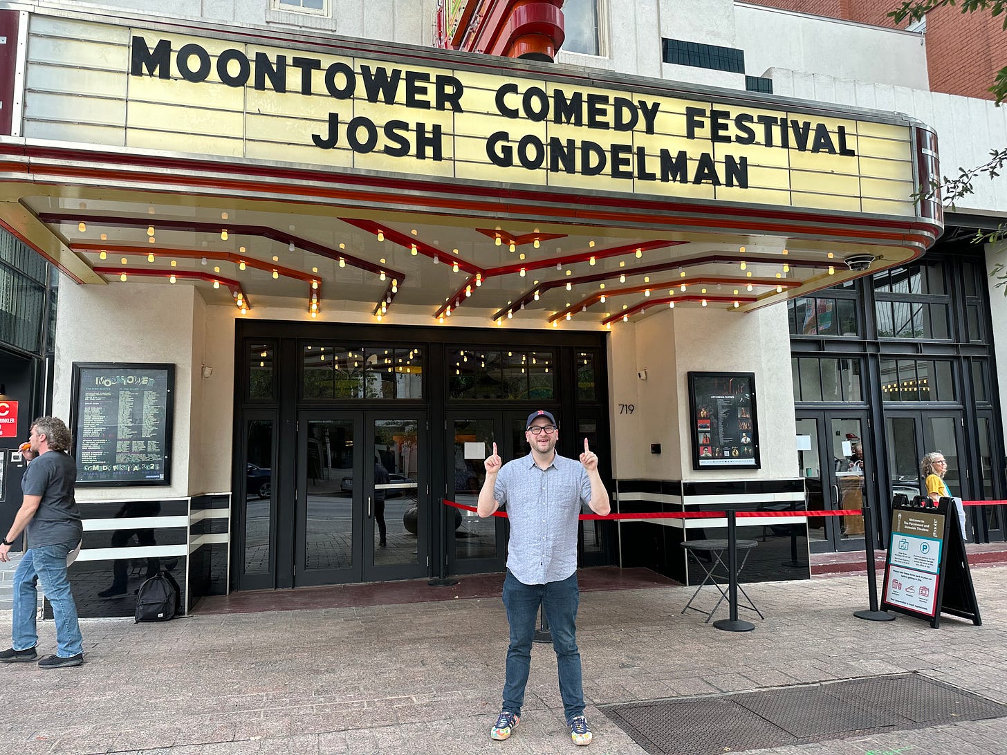 Me standing in front of the State Theatre in Austin pointing up at the marquee with my name on it.