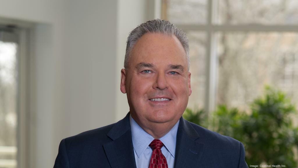 Headshot of former Cardinal Health CEO Mike C. Kaufmann, smiling in a blue suit with red tie